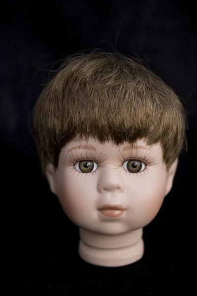 Kleiner Junge Puppe Kopf auf schwarzem Hintergrund — Stockfoto