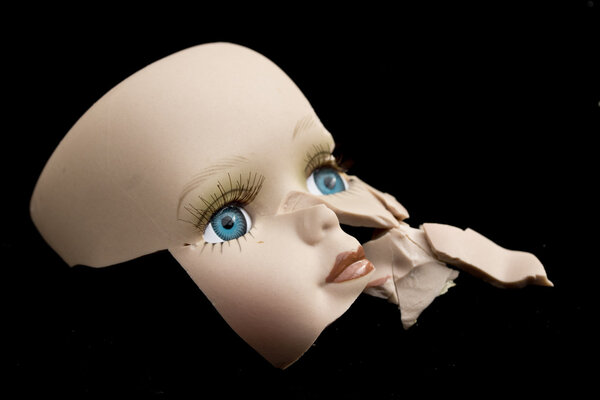 Broken Doll Body Parts on Black Background