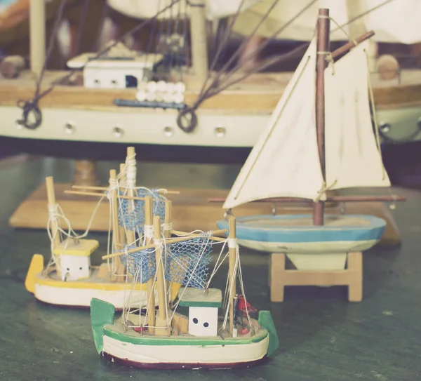 Старинные ретро антикварные игрушечные лодки разных размеров на столе — стоковое фото