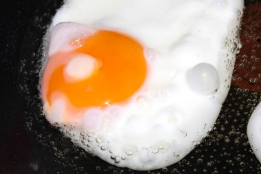 Close up of Fresh egg frying in a pan with golden yolk