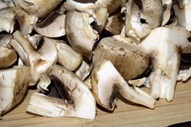 Doğranmış çiğ mantarları doğrama tahtasına koyup pişirmek için hazırlayın.