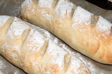 Taze ev yapımı baget ekmeği fırından yeni çıkmış ve hala pişirme tepsisinde duruyor.