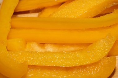 Dilimlenmiş tatlı biberi ahşap kesme tahtasına yakın tut.