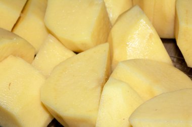 Soyulmuş ve doğranmış çiğ patatesler kavrulmaya hazır.