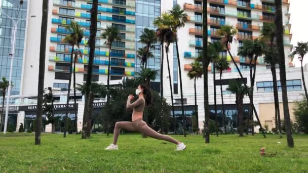 Mujer en la mascarilla haciendo ejercicio en la ciudad. — Vídeo de stock