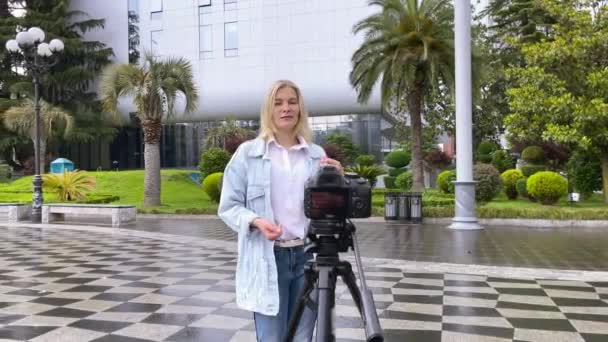Blogueiro filmando a si mesma na câmera na cidade — Vídeo de Stock