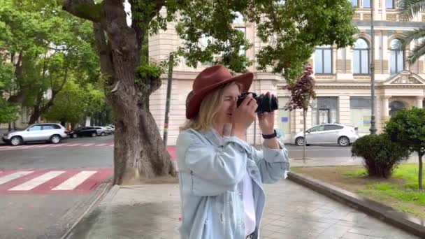 Fotograf robi zdjęcia na kamerze w mieście — Wideo stockowe