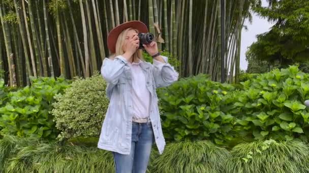 Fotograf Tar en bild på en kamera i trädgården — Stockvideo