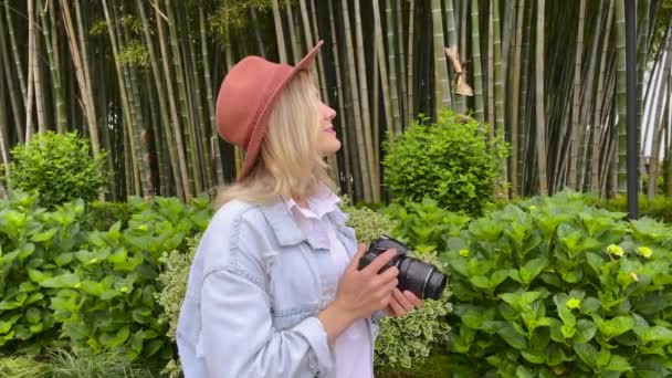 Photographe prend une photo sur un appareil photo dans le jardin — Video