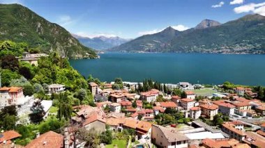 Menaggio Como İtalya 'nın güzel manzarasını keşfedin. Parlak güneş ışığı büyüleyici çatıları, yemyeşil dağları ve berrak mavi gölü ortaya çıkarıyor. Doğanın rahatlığını ve keyfini davet ediyor..