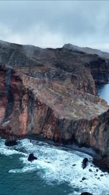 Portekiz 'in Madeira Adası' ndaki Punta San Lorenzo 'nun engebeli güzelliğini keşfedin. Kayalık kayalıklara vuran dalgaları ve karamsar gökyüzü atmosferini hissedin..