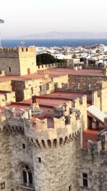 Parlak bir günde, Rodos Yunanistan 'daki Büyük Üstat Sarayı' nın mimarisini ve yapısını gösteren yüksek bir açı. Arka planda uzak binalar ve okyanus var..