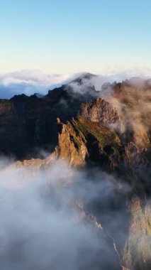 Güneş doğarken Orta Madeira 'nın inanılmaz dağ zirvelerine bakın. Bulutların yüksek noktalar arasında yavaşça hareket ettiğini ve güzel bir manzara yarattığını görüyor musun?.