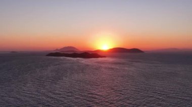 Güneş Rodos Yunanistan yakınlarındaki Ege Denizi 'nden doğuyor. Su sakin ve güneşin canlı renklerini yansıtıyor. Güzel ve sakin bir sabah manzarası yaratıyor..