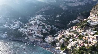 Positano İtalya 'nın yüksek manzarası. Parlak binalar Amalfi Sahili boyunca sarp kayalıklara tutunur. Güneşli bir günde turkuaz denizde tekneler görülebilir..