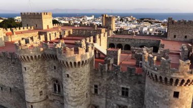Büyük üstadın Rhodos Sarayı güzel manzaralar sunar. Bu görüntü, gün ışığında çevredeki taş yapıya ve uzak denize havadan bir bakış sunuyor..