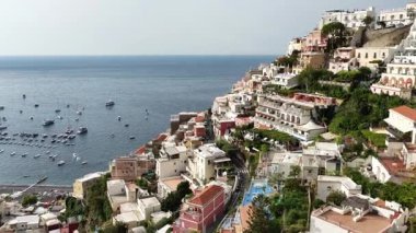 Manzaralı bir hava perspektifi, Positano İtalya 'nın mimarisi ve kıyı şeridini gözler önüne seriyor. Tırren Denizi 'nin yamaçlarındaki mavi sulara ve teknelere bakın..