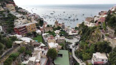 İtalya 'nın güzel şehri Positano' yu yukarıdan keşfedin. Tepenin yamacında, Tyrhenian Denizi 'ne bakan binalar yuva yapar. Birçok tekne geniş sularda yüzüyor..