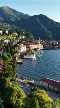 Güneşli göl kenti, tekneleri ve dağları olan, sakin limanın üzerinde süzülen hava, ışıldayan su, pastel