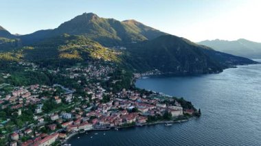 Kırmızı çatı kasabası, güneşli dağ yamaçlarının altında mavi körfezi kucaklıyor, dar sokaklar, rıhtım ve terasotta.