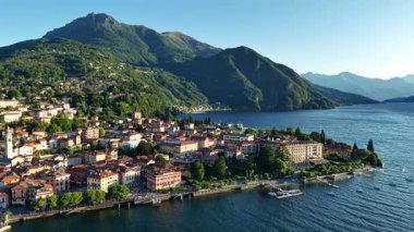 Altın saat rıhtım kenti havadan süzülüyor yumuşak sıcak ışık ön cephelerde demirli dağ siluetinde.