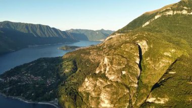 Derin fiyortlara bakan dramatik uçurum, havadaki altın ışık dokulu kaya yüzeyini ve dik tepeleri ortaya çıkarıyor.