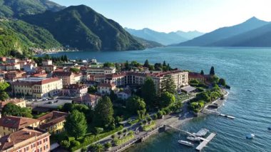 Mavi göl kıyısında lüks bir liman oteli, büyük cephe üzerinde hava temizliği, manikürlü bahçeler ve deniz kenarı.