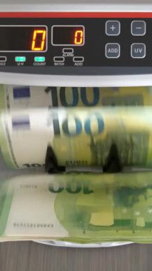 100 Euro 'luk banknotlar bir para sayacı tarafından hızla sayılıyor. Sayaç, sayım makinesinden geçen banknotların sayısını gösterir.