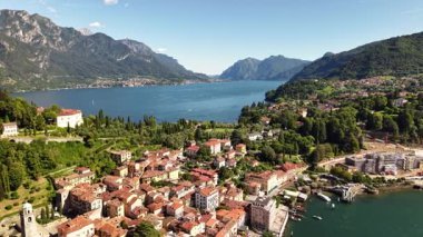 Havadan bakıldığında Como Gölü 'nün nefes kesici manzarası görülüyor. Resimli kasabalar kıyıda sıralanır. Arka planda dağlar yükselir ve tekneler suda yüzer..