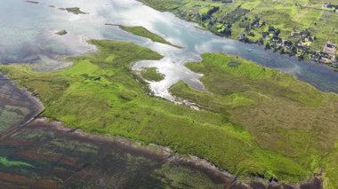 Göl manzarası, Sunart Gölü 'nün karayla buluştuğu halteri yakalar. Yeşil gelgit alanları ve su üzerindeki yansımalar İskoçya 'da açıkça görülebilir..