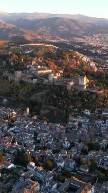Granada İspanya 'nın güzel bir hava perspektifini keşfedin. Gün batımının sıcacık ışığında Alhambra sarayını ve şehri görün. Dağları da arka plan olarak kullanın..