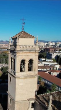 Parlak mavi gökyüzünün altındaki Granada Katedrali 'nin çan kulesini bir hava görüntüsü sunar. Şehir manzarası ve Granada İspanya 'nın uzak dağları arka planda görülebilir..