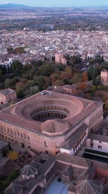 Bu, İspanya 'nın Granada bölgesindeki Alhambra kompleksinin bir parçası olan V. Carlos Sarayı' nın havadan bir perspektifini gösteriyor. Şehir görünümleri arka planda görünür.