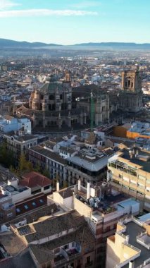 İnsansız hava aracı Granada 'nın kentsel manzarasını gösteriyor. Binaların evleri ve Granada Katedrali açık ve güneşli bir günde görülebilir. Arka planda uzak dağlar var.
