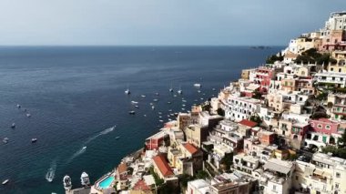 Bu, Positano İtalya 'nın güzel bir hava perspektifini gösteriyor. Bu kıyı kasabasında güneşli bir günde renkli binaları ve tekneleri görün..