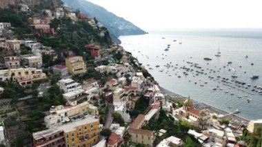 Positano İtalya 'nın çarpıcı sahil şeridini keşfedin. Binalar, güneşli bir günde benekli Tyrhenian Denizi 'ne bakan yamaçlara tutunur..