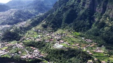 Gündüz havası yeşil dağ yamaçlarının arasına kurulmuş güzel bir Madeira köyü gösteriyor..
