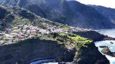 Çarpıcı hava manzaraları Madeira 'daki dik kayalıklara kurulmuş büyüleyici bir kıyı köyünü gösteriyor. Yeşil tarım terasları Atlantik Okyanusu 'na iniyor..