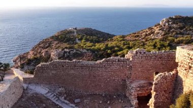Rodos Yunanistan 'daki tarihi şato kalıntılarının panoramik manzarası. Taş duvarlar açık mavi Ege Denizi 'ne bakan bir tepenin üzerinde duruyor..