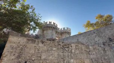 Rodos Yunanistan 'daki tarihi ortaçağ şatosunu araştırıyorum. Taş duvarlar eski kuleler ve siperler berrak mavi gökyüzünün altında yükseliyor..