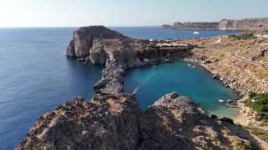 Rodos 'taki Saint Pauls Körfezi' nin hava perspektifi, açık mavi suları, engebeli uçurumları ve güneşli bir günde küçük bir plajı gözler önüne seriyor.
