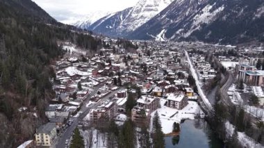 Hava görüntüsü Chamonix Mont Blanc 'ı kışın yakalıyor. Beyaz dağların arasında bir vadiye yerleşmiş kar örtüleri..