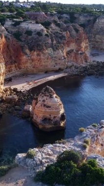 Altın saat ışığı Portekiz 'in çarpıcı Algarve kıyılarını aydınlatıyor.