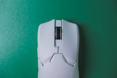 Beyaz bir bilgisayar faresinin yeşil desenli arka planda görünür bir kaydırma tekerleği ve fotokopi alanı olan üst görüntüsü. Teknoloji, ofis ve alet kavramları için ideal.