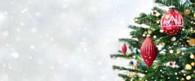 Kırmızı süslemeli yılbaşı ağacı. Arka planda bokeh, kıvılcım, parıltı var. Mutlu Noeller ve mutlu yıllar tebrik kartı. Xmas ve kış tatili. Noel bayrağı