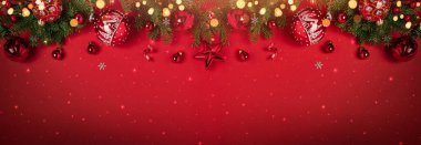 Kırmızı arka planda kırmızı parıltılı bokeh ile süslenmiş Noel ağacı dalları. Mutlu Noeller ve mutlu yıllar tebrik kartı. Xmas ve kış tatili. Noel zamanı, üst manzara