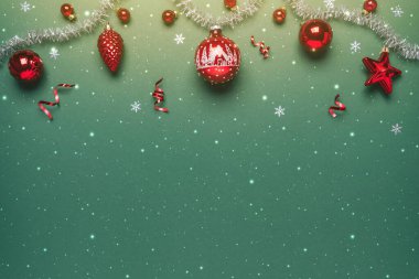 Yeşil arka planda gümüş çelenkli Noel kırmızısı süslemeleri. Mutlu Noeller ve mutlu yıllar tebrik kartı. Xmas ve kış tatili, Noel geniş afişi, üst manzara