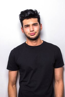 Siyah tişörtlü sıkıcı adam duyguları taklit ediyor.