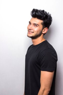 Siyah tişörtlü gülümseyen adam duygularını taklit ediyor.