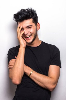 Siyah tişörtlü gülümseyen adam duygularını taklit ediyor.